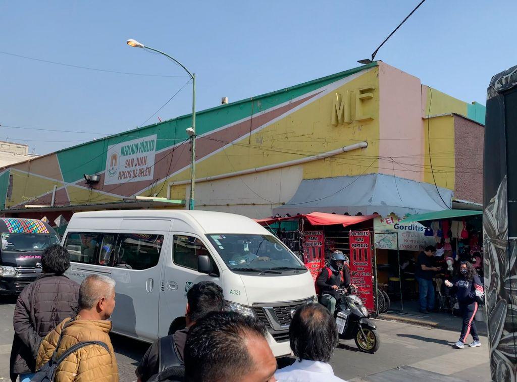 trucks, cars, motos and people outside the Mercado San Juan