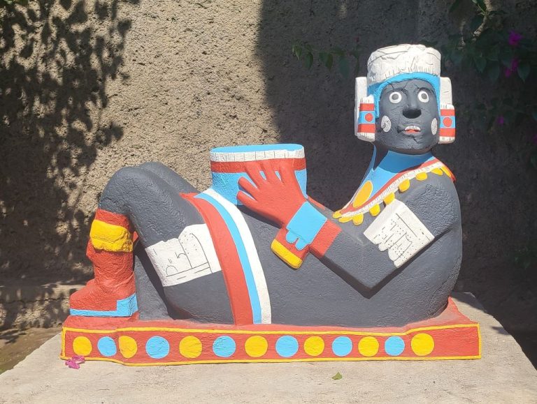 colorful sculpture of pre-columbian man reclining